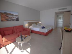 a room with a bed and a couch and a table at Hotel Lanzarote Village in Puerto del Carmen