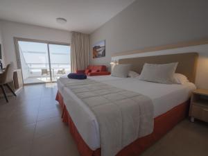 a bedroom with a large bed with a view of the ocean at Hotel Lanzarote Village in Puerto del Carmen
