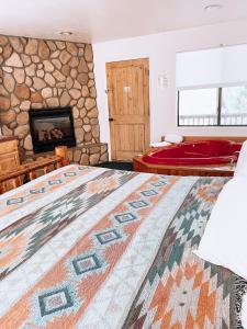 1 dormitorio con chimenea de piedra y alfombra grande en Creekside Lodge and Cabins, en Mayer
