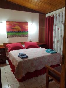 um quarto com uma cama com toalhas vermelhas e azuis em Wanda Apart Hotel Las Palmas em Wanda