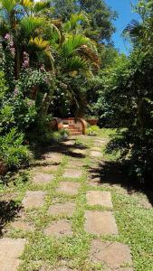 um caminho de pedra num jardim com plantas e árvores em Wanda Apart Hotel Las Palmas em Wanda