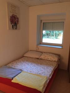 a small bed in a room with a window at Capital apartments - CITY CENTRE in Mostar