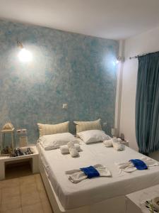 a bedroom with a large white bed with blue wallpaper at Studio Filareti in Ios Chora