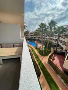 einen Balkon eines Gebäudes mit Poolblick in der Unterkunft El Rincon Getaway Sea & Golf in Playa Flamenca