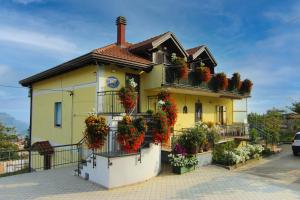 une maison jaune avec des boîtes de fleurs sur le balcon dans l'établissement B&B Kebontà, à Agerola