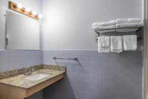a bathroom with a sink and a mirror and towels at Travelodge by Wyndham Spirit Lake/Okoboji in Spirit Lake +46 photos