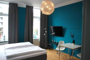 ein Schlafzimmer mit einem Bett und einer blauen Wand in der Unterkunft Hotel Domstern in Köln