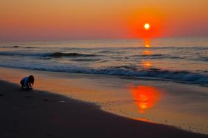 een persoon die op het strand speelt bij zonsondergang bij Myrtle Beach Resort in Myrtle Beach
