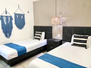 ein Schlafzimmer mit zwei Betten und einem Kronleuchter in der Unterkunft Coco Suites by Andiani Travel in Cancún