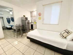 ein Zimmer mit einem Bett und eine Küche mit einem Tisch in der Unterkunft Coco Suites by Andiani Travel in Cancún + 102 Fotos