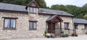 a stone building with windows and plants on it at Henblas Holiday Cottages in Abergele