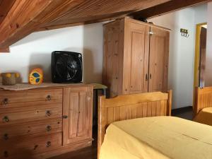 1 dormitorio con cama y vestidor con TV en Apartamento Pero Cabo Frio RJ, en Cabo Frío