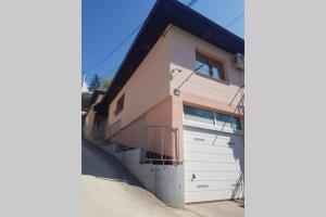 una casa con una puerta de garaje y una valla en Apartman sa garažom i internetom, en Sarajevo