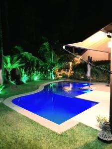 a blue swimming pool at night with lights at Oka Beach Residence in Porto De Galinhas