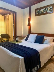 een slaapkamer met een groot bed en een tafel bij Pousada do Figa in Visconde De Maua