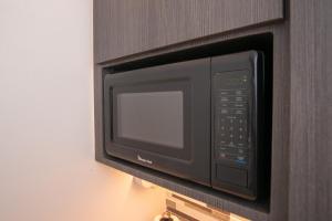 a microwave oven attached to a wall at Senderos 4 a cozy studio 4 min from the beach in Rincon