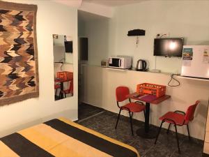 a room with a table and two chairs and a microwave at Apart Eva Luna Departamentos y Habitaciones con baño privado in Las Grutas