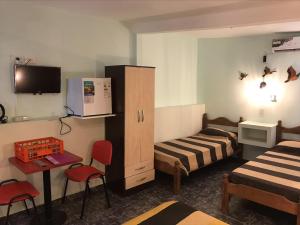 a hotel room with two beds and a tv at Apart Eva Luna Departamentos y Habitaciones con baño privado in Las Grutas