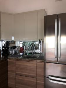 a kitchen with white cabinets and a stainless steel refrigerator at Skippers View Sunny Balcony in Eastbourne