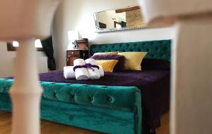 ein Schlafzimmer mit einem grünen Bett und zwei Handtüchern in der Unterkunft B&B Tenuta della Duchessa in Porto Viro