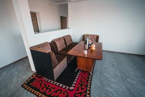 una sala de estar con un sofá y una mesa en Sarysoul Mountainlodge / Pamirextreme, en Sary-Tash