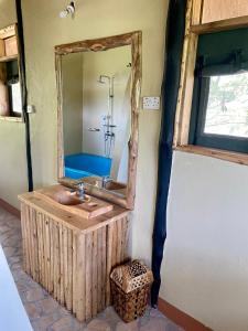 W łazience znajduje się umywalka i lustro. w obiekcie Enshama Game Lodge and Campsite w mieście Katunguru
