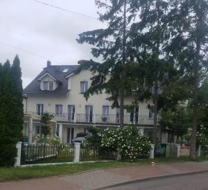 a large white house with a fence and trees at Rewa in Rewal