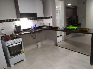 una grande cucina con fornelli e lavello di Cobertura Fort do Pontal ad Arraial do Cabo Altre 3 foto