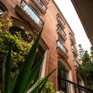 ein Backsteingebäude mit Fenstern und Pflanzen davor in der Unterkunft Sendero Hotel in Actopan