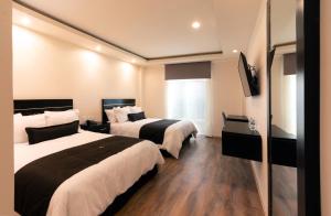 a hotel room with two beds and a flat screen tv at Sendero Hotel in Actopan +21 photos
