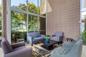 a lobby with chairs and a table and windows at Clarion Inn Sheffield Muscle Shoals in Sheffield