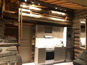 una cucina con fornello forno superiore accanto a un muro di pietra di Rukanloiste a Ruka Altre 16 foto