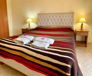 1 dormitorio con 1 cama grande y toallas. en Carlos Paz Departamentos en Villa Carlos Paz
