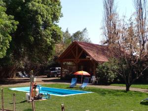 a pavilion with two chairs and an umbrella in a yard at CABAÑA RUSTICANA in Casas de Batuco