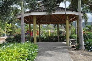 a wooden pavilion with a bench in a garden at Epic Paradise in Ocho Rios