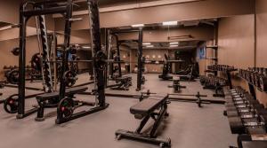 une salle de sport avec plusieurs rangées de porte-squats et de poids dans l'établissement Radisson Blu Marina Palace Hotel, Turku, à Turku