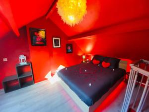 - une chambre rouge avec un lit aux murs rouges dans l'établissement La Valentine Spa, à Béthisy-Saint-Pierre