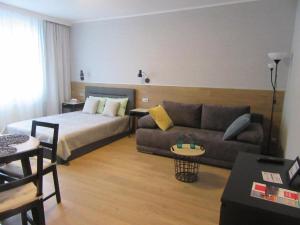 a hotel room with a bed and a couch at Studio Four Seasons with parking place in Gdańsk