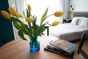 a vase with yellow flowers sitting on a table at Studio Four Seasons with parking place in Gdańsk