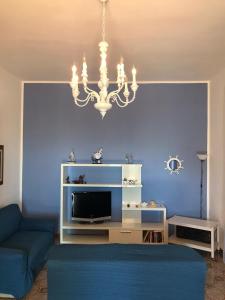 una sala de estar con una pared azul con una lámpara de araña en Villa Melina en Siracusa