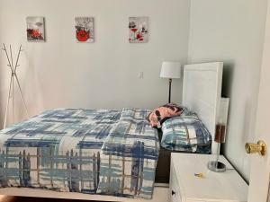 a bedroom with a bed and a table with a lamp at One Bedroom queen bed Sharing Washroom in Tiger Sweet House License## in Richmond