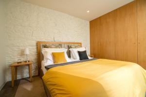 a bedroom with a large bed with yellow sheets and pillows at Welcome Madeira Apartments in Funchal