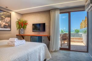 a bedroom with a bed and a view of a balcony at Pousada Villa Italiana in São Miguel dos Milagres