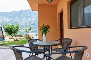 een tafel met stoelen en een vaas met bloemen op een patio bij Apartments Barbara in Kotor