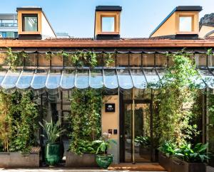 an old building with plants on the facade at Vico Milano in Milan