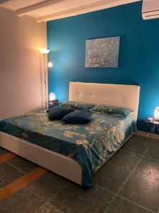 a bedroom with a bed with a blue wall at Iris Apartment in Bari