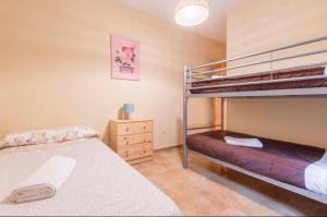 a bedroom with two bunk beds and a dresser at Apartamento Turístico Javalambre in Camarena de la Sierra