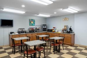 Ramada by Wyndham Maggie Valley في ماجي فالي: غرفة مع طاولات وكراسي في مطبخ