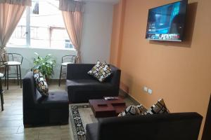 een woonkamer met 2 banken en een flatscreen-tv bij Panchi´s House in Baños