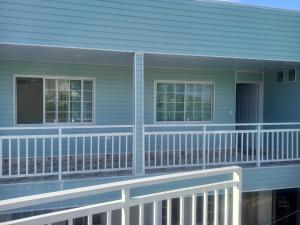 圣安德烈斯SWEET BREEZE的蓝色房子,阳台上有白色栏杆